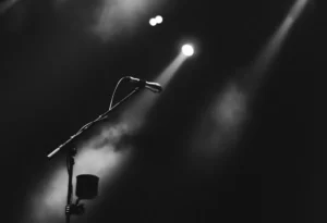 Image of microphone stand on dark stage illuminated by spotlight for the BNI Synergy Member Spotlight Series